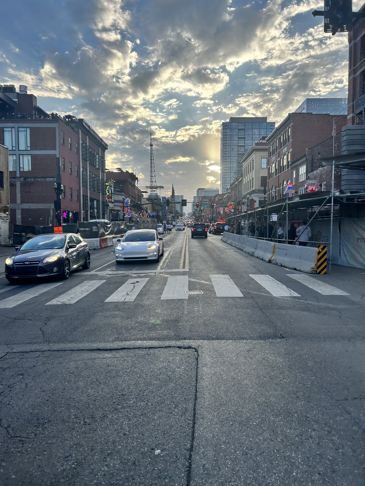 A downtown Nashville street at dusk, brick buildings and city sky
